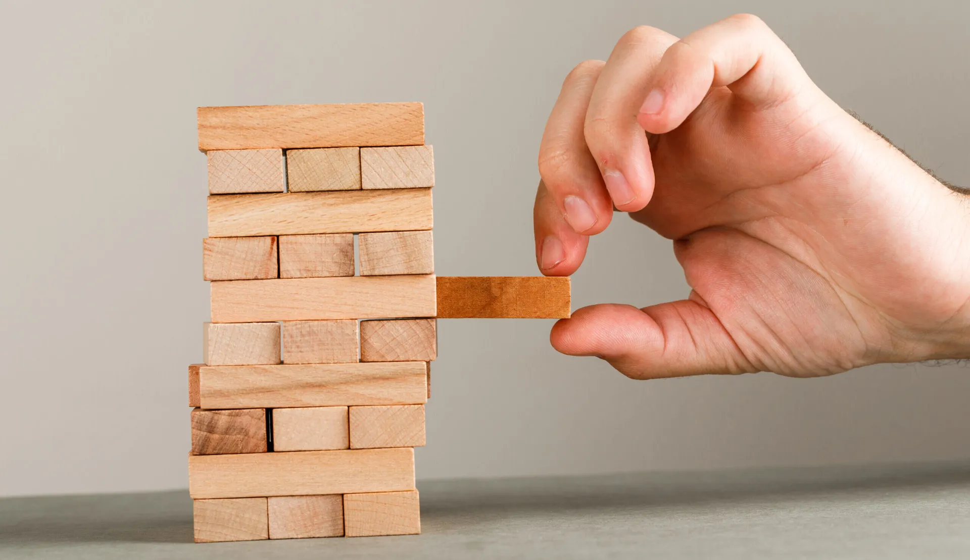 a tack of sticks arranges and a person is trying to get on stick.